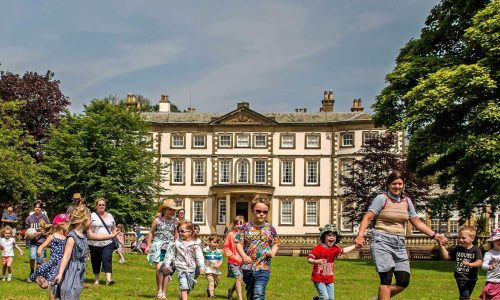Families running across the grounds of Sewerby Hall - in an interactive Rusticus Adventure